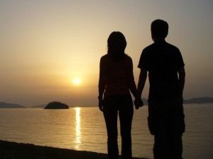 A Japanese couple holding hands on the beach