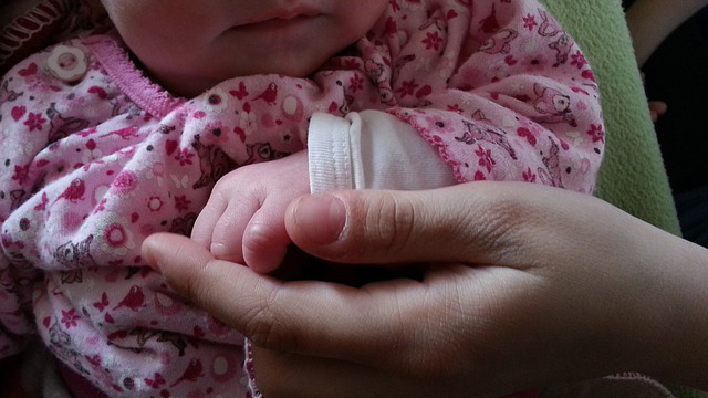 "Baby Holding Hands Hands" by beeki via Pixabay (CreativeCommons)